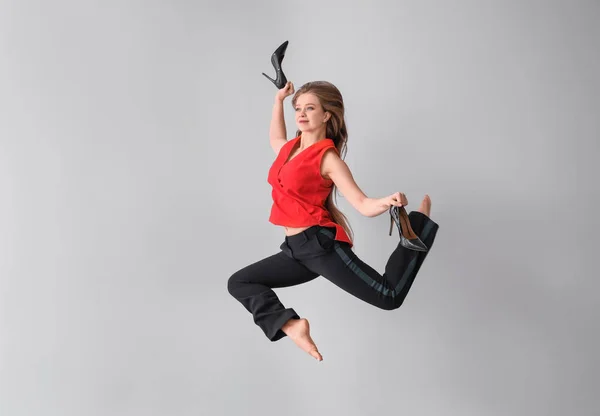 Jumping businesswoman on light background — Stock Photo, Image