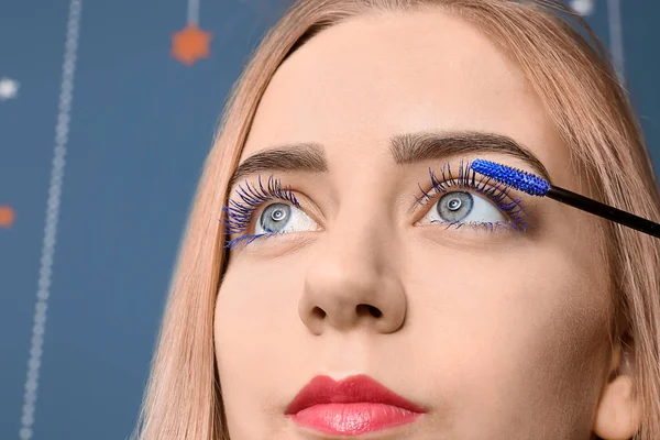 Beautiful young woman applying color mascara, closeup — Stock Photo, Image