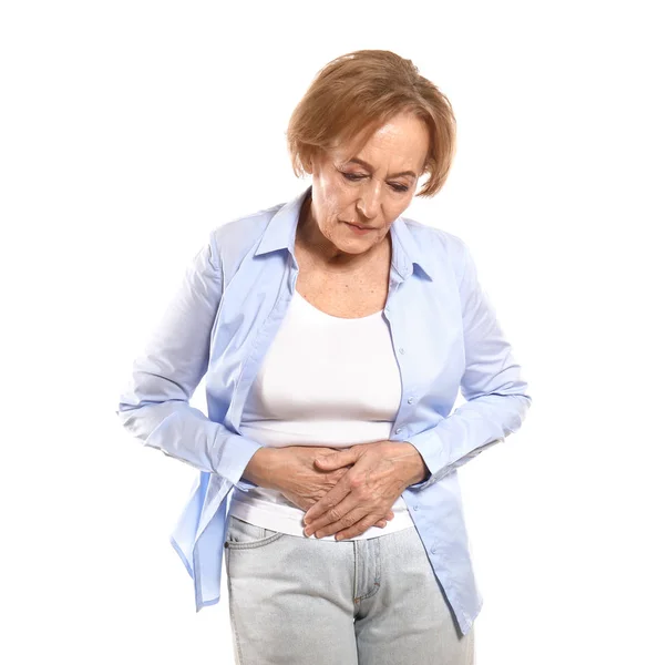 Beautiful mature woman suffering from stomach ache against white background — Stock Photo, Image