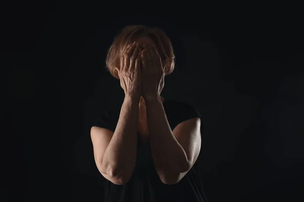 Crying mature woman on dark background — Stock Photo, Image