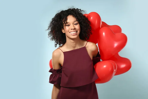 Mulher afro-americana feliz com balões de ar no fundo de cor — Fotografia de Stock
