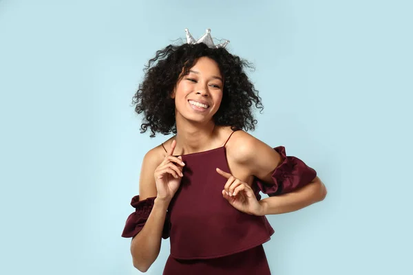 Feliz mulher afro-americana usando coroa no fundo de cor — Fotografia de Stock