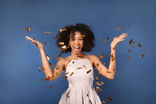 Feliz mulher afro-americana jogando confete no fundo de cor — Fotografia de Stock