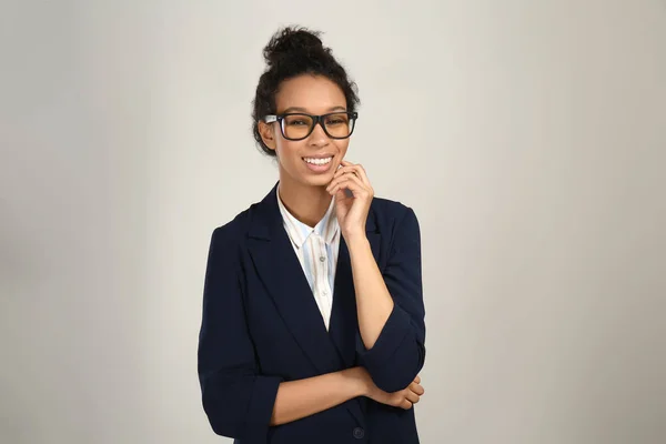 Young African-American businesswoman on grey background — Stock Photo, Image