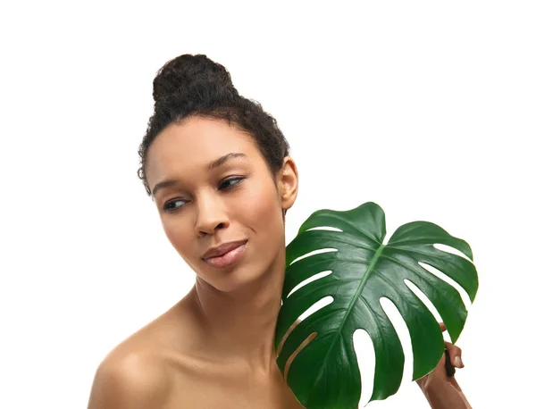 Unga afroamerikanska kvinna med tropiska löv på vit bakgrund — Stockfoto