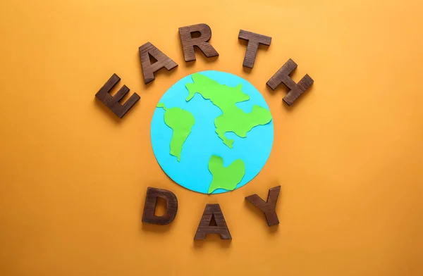 Text Earth Day sammansatt av bokstäver och form av planeten på färg bakgrund — Stockfoto