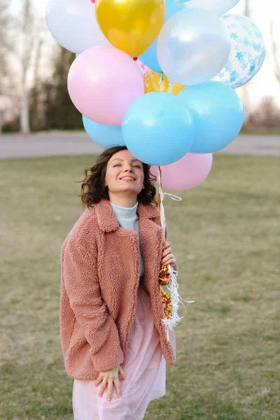 Happy young girl with air balloons in park — Stock Photo, Image