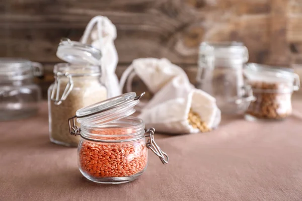 Glass jar with lentils on kitchen table — Stock Photo, Image