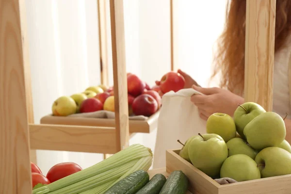 Egy nő ökotáskával gyümölcsöt vásárol a boltban. Zéró hulladék fogalma — Stock Fotó