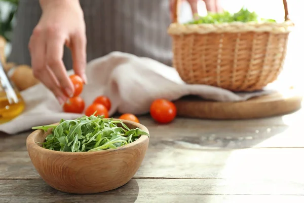 Kom met lekkere verse rucola op houten tafel — Stockfoto