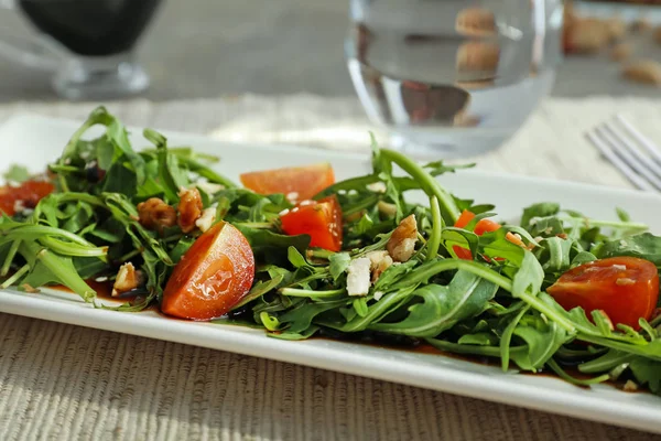Plate with tasty arugula salad on table — Stock Photo, Image