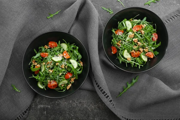 Plates with tasty arugula salad on table — Stock Photo, Image