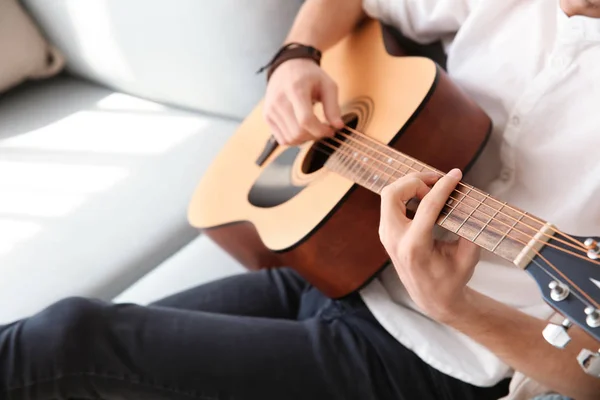 Yakışıklı genç adam evde gitar çalıyor. — Stok fotoğraf