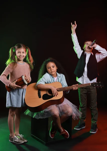 Banda de pequeños músicos sobre fondo oscuro — Foto de Stock