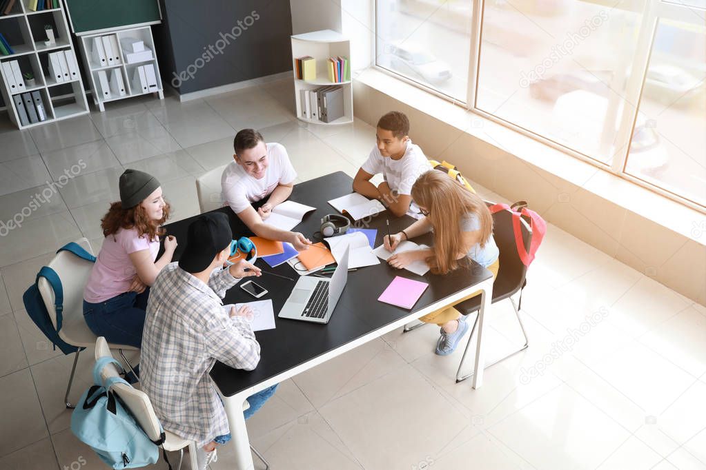 Group of teenagers studying together in school