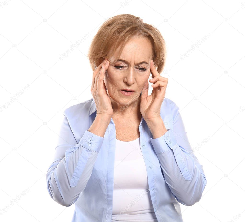 Beautiful mature woman suffering from head ache against white background