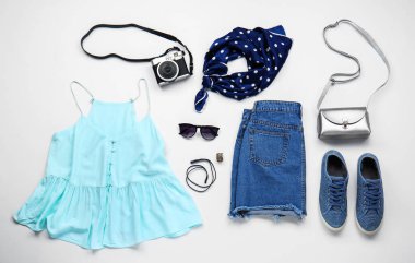 Beyaz arka planda kadın giysileri, aksesuarlar ve fotoğraf kamerası seti