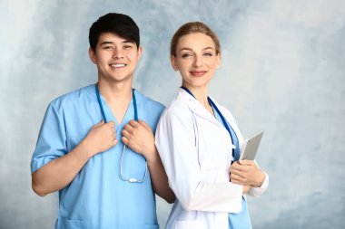 Renkli arka planda kadın doktor ve erkek tıp asistanı portresi