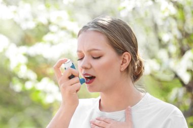 Bahar gününde inhaler astım saldırısı olan kadın