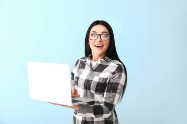 Renkli arka planda dizüstü bilgisayar ile Heyecanlı kadın programcı
