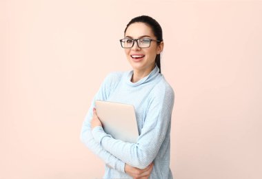 Işık arkaplanda dizüstü bilgisayarı olan kadın programcı