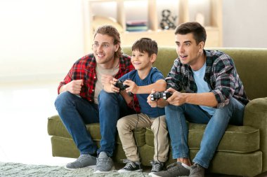 Evde video oyunu oynayan evlatlık çocuk ile eşcinsel çift