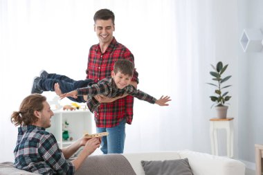 Mutlu eşcinsel çift evde evlatlık çocuk ile oynarken