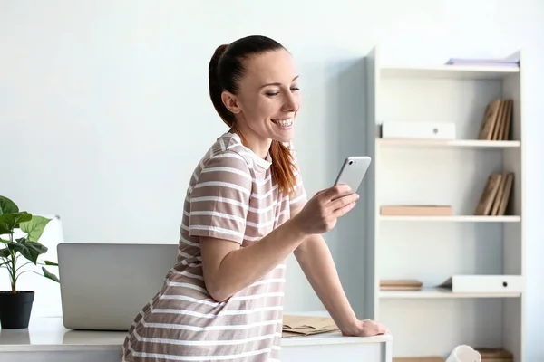 Woman with mobile phone indoors — Stock Photo, Image
