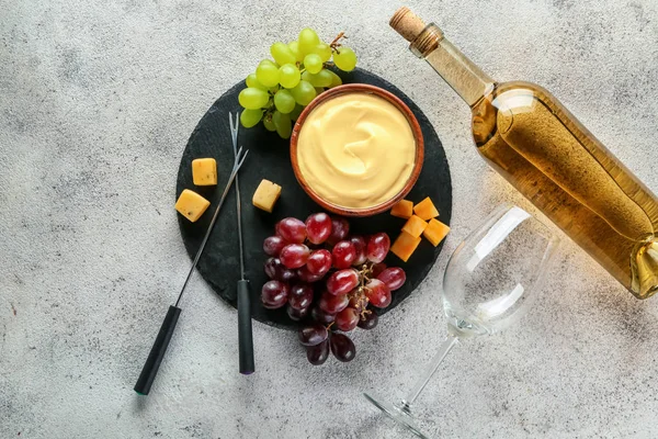 Cheese fondue with wine on grey background