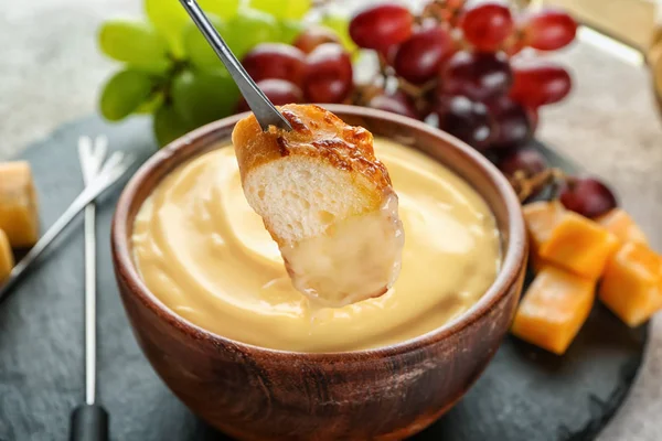 Sumergir el pan en fondue de queso, primer plano —  Fotos de Stock