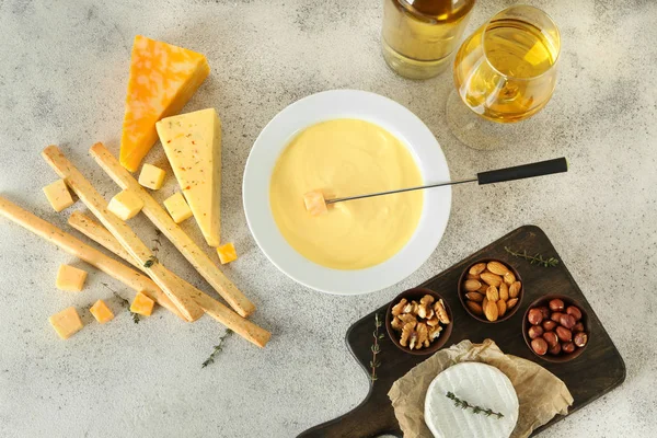 Fondue de queso con aperitivos y vino sobre fondo gris —  Fotos de Stock