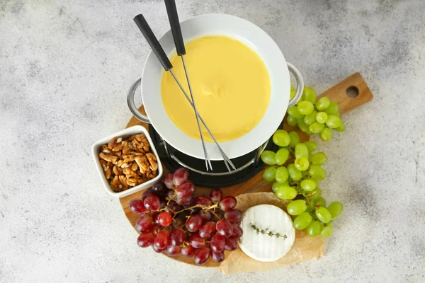 Fondue de queso con snacks sobre fondo gris —  Fotos de Stock