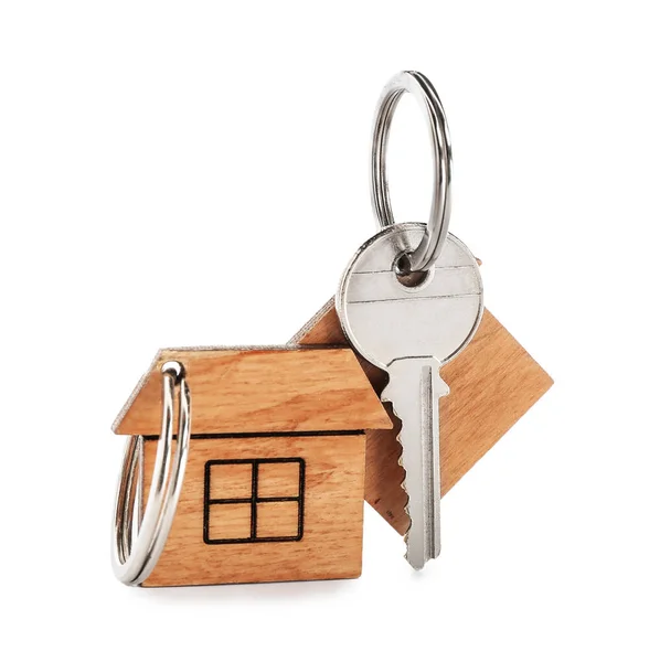 钥匙与小饰品在白色背景的房子形状 — 图库照片
