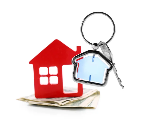 Figura de casa, dinero y llave sobre fondo blanco. Concepto de compra de bienes raíces — Foto de Stock