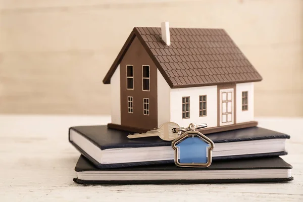 Model of house, books and key on table — Stock Photo, Image