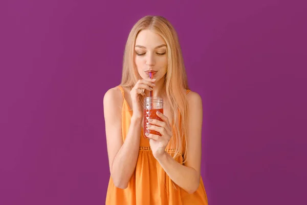 Beautiful young woman with fresh juice on color background — Stock Photo, Image