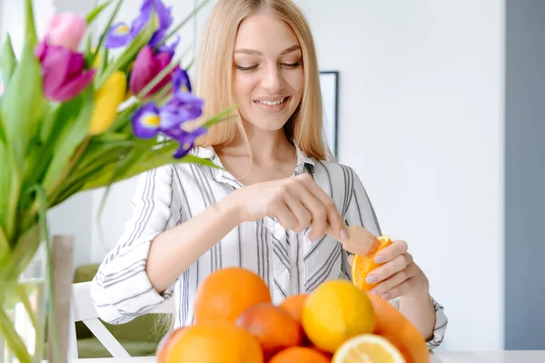 Hermosa joven mujer exprimiendo jugo de naranja en casa — Foto de Stock