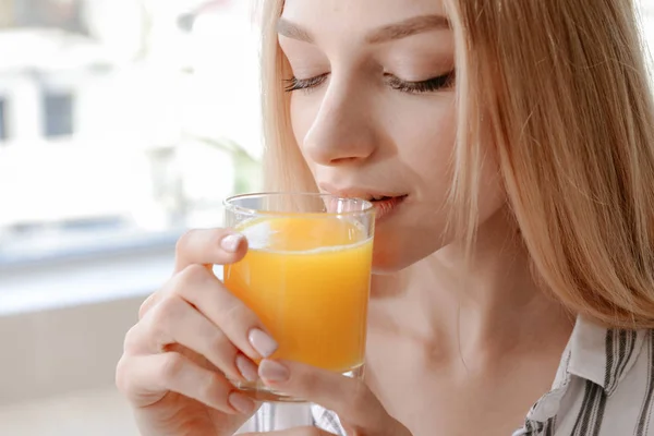 Mulher bonita bebendo suco fresco em casa — Fotografia de Stock