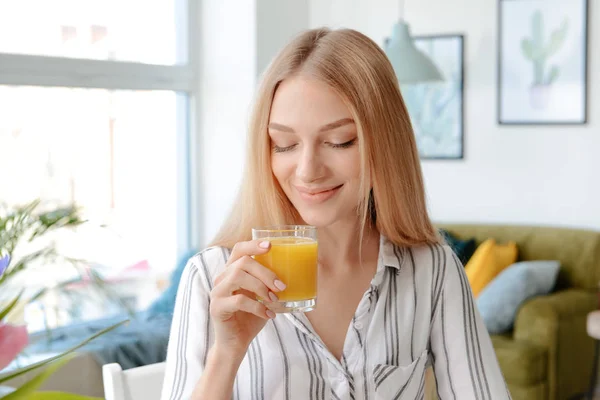 Beautiful young woman drinking fresh juice at home — Stock Photo, Image