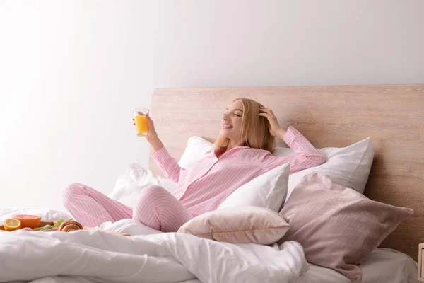 Красивая молодая женщина завтракает в постели — стоковое фото