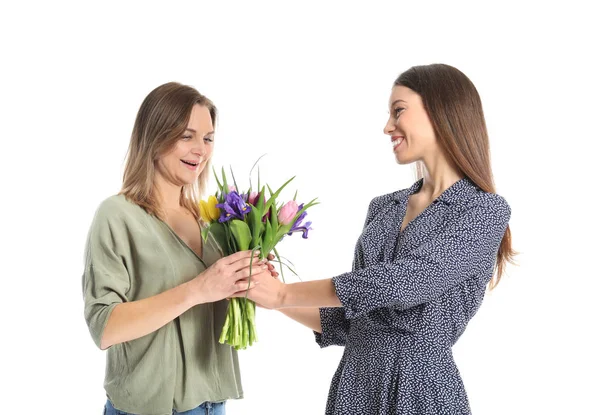 Dochter groet haar moeder met boeket van bloemen op witte achtergrond — Stockfoto