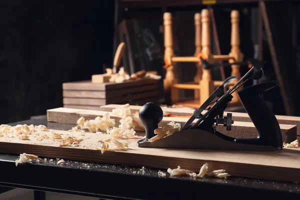 Плотницький план згладжування з дерев'яною планку на столі в майстерні — стокове фото