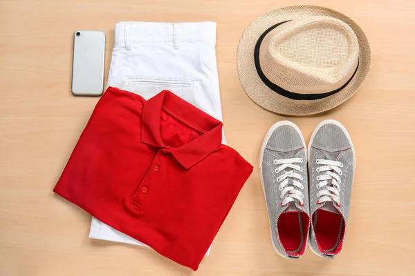 Garnitur Kleidung, Hut und Telefon auf Holzgrund — Stockfoto