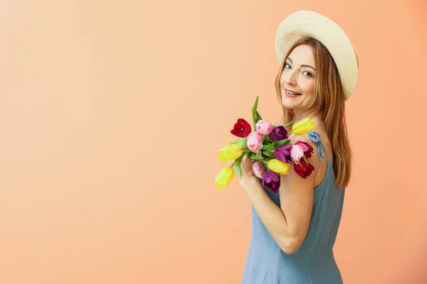 Porträtt av mogen kvinna med blommor på färg bakgrund — Stockfoto