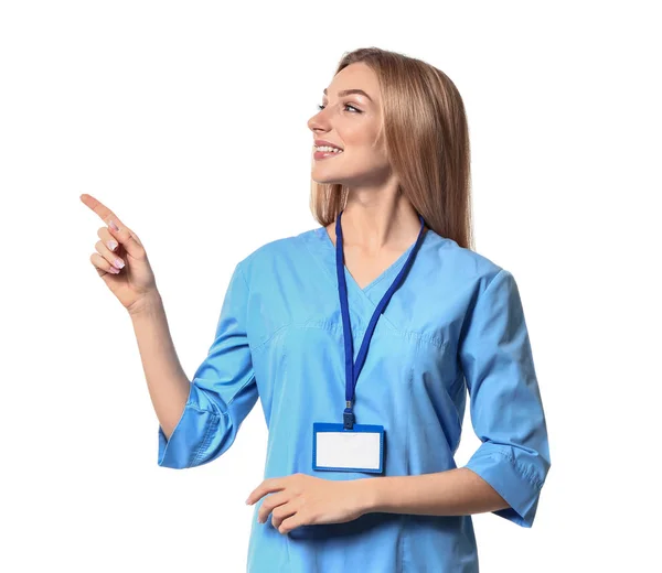 Kvinnlig medicinsk assistent pekar på något på vit bakgrund — Stockfoto