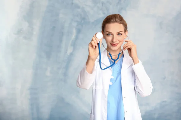 Portret van de vrouwelijke arts met stethoscoop op kleur achtergrond — Stockfoto