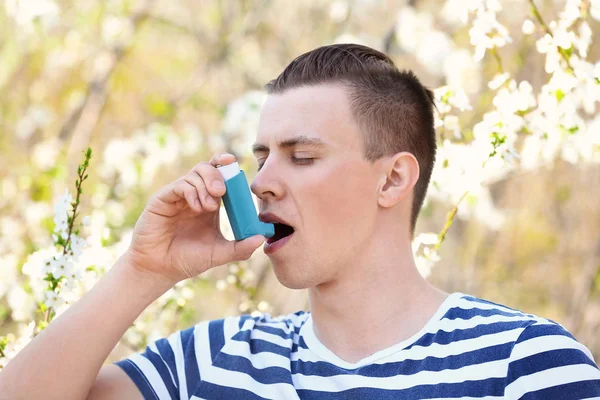 Людина з інгалятором, що атакує астму на весняний день — стокове фото