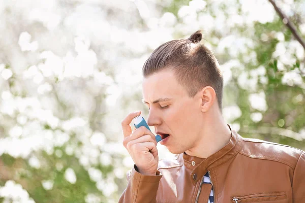 Man with inhaler having asthma attack on spring day — Stock Photo, Image