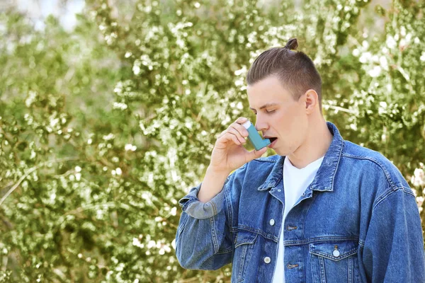 Man with inhaler having asthma attack on spring day — Stock Photo, Image