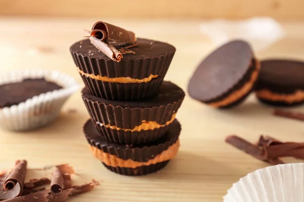 Smakelijke chocolade pindakaas kopjes op houten tafel — Stockfoto